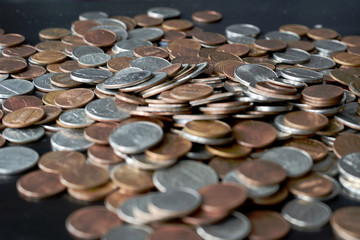 A pile of American cents on an old black wooden surface close-up. Money background