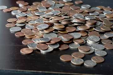 A pile of American cents on an old black wooden surface close-up. Money background