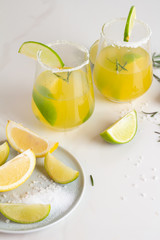 lime drink in a glass with salt and citruses