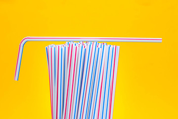 Drinking plastic straws on a yellow background. Colorful of plastic straws used for drinking water or soft drinks. Copy space