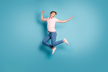 Fototapeta na wymiar Portrait of funny enthusiastic guy enjoy spring vacation feel crazy emotion scream jump wear good-looking outfit sneakers isolated over blue color background