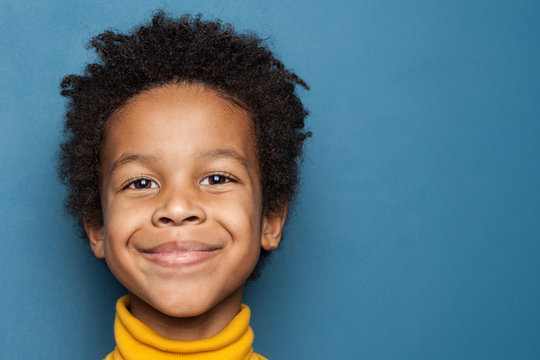 Smiling Kid Boy Portrait. Little African American Child Boy On Blue Background