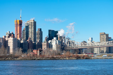 Midtown Manhattan Skyline along the East River in New York City with the Queensboro Bridge