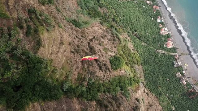 Drone aerial view of two paragliders flying over clouds and in Madeira island, Portugal