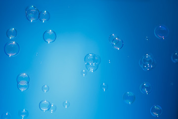 Soap bubbles in air with  float on blue background
