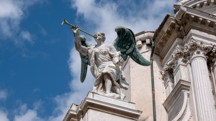 Fototapeta na wymiar Details of an Angel with a trumpet at the facade of Santa Maria del Giglio church (Santa Maria Zobenigo) in Venice, Italy