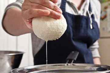 Making cheese curds by straining out water from milk.