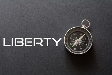 Liberty word written on black background with compass