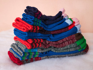 Warm winter wool knitted socks of different sizes and different colors. Waiting for the winter.