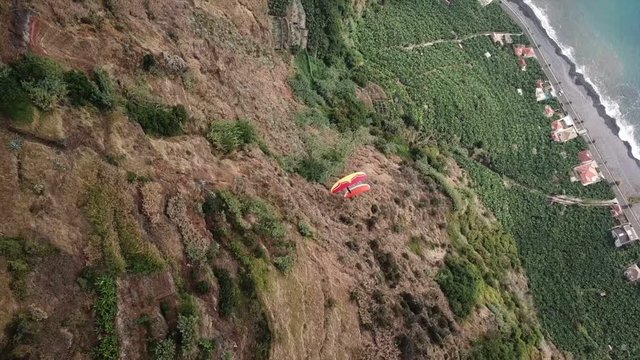 Drone aerial view of two paragliders flying over clouds and in Madeira island, Portugal