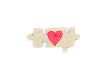 Puzzle with a red heart on the white isolation background. Valentine's day stock photo with empty space for your text. For web, print, postcard, background and wallpaper 