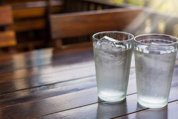 2 Glass with ice and cold water on wood table.