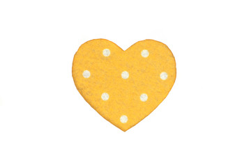 Оne yellow with white polka dot color felt heart on a white isolated background. Stock photo for the day of St. Valentine with empty space for your text. For web, print, postcards and wallpaper.