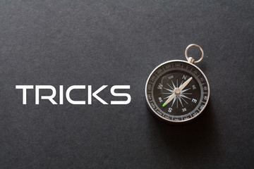 Trick word written on black background with compass