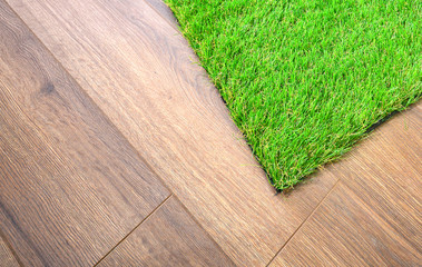 Artificial grass lie on the laminate floor