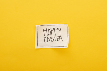 top view of greeting card with happy Easter lettering on yellow colorful background