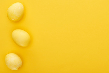 Top view of painted Easter eggs on colorful yellow background