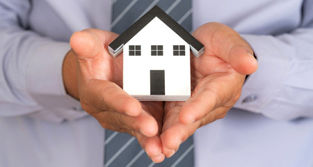 Insurance house concept, House model on support hands, Protection house safe protect