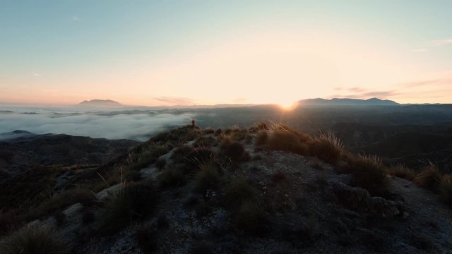 Silhouette of hiker on top of mountain peak