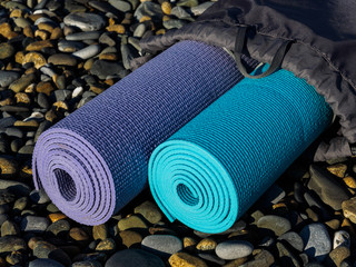 Purple and blue yoga or Pilates mats on sea rocks