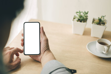 Mockup image blank white screen cell phone.man hand holding texting using mobile on desk at office.background empty space for advertise text.people contact marketing business,technology 