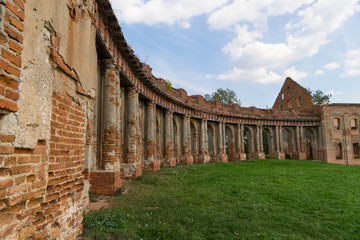 Obraz premium The ruins of the old palace of the ancient noble family of Sapieha in Ruzhany: a semicircular brick gallery with arches and columns