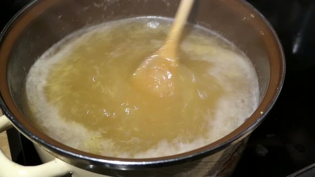 Cooking elder beery flower head jam confiture in a pot. filling sugar into the pot.