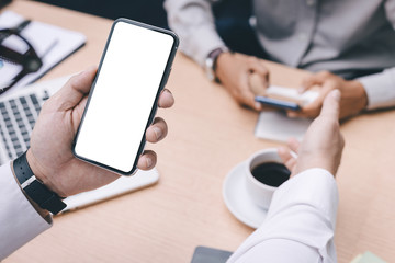 Mockup image blank white screen cell phone.man hand holding texting using mobile on desk at office.background empty space for advertise text.people contact marketing business,technology 