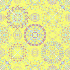 Seamless pattern. Round patterns located at the grid nodes are geometrically symmetrical. Floral motifs, delicate pink-blue shades on yellow. Wallpaper in the nursery, fabric for clothes, curtains.