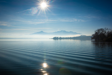 Sonne und Nebel über See und Berge der Alpen - 314510246