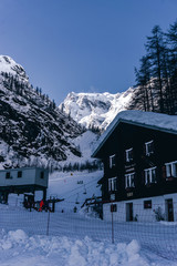 The town of Macugnaga, in the Italian Alps, with its typical houses, the snow and Monte Rosa - December 2019.