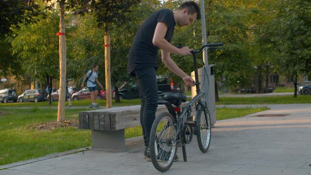 Man prepares folding bike for ride