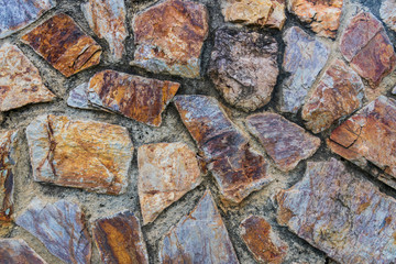 A background photo of a stunning and unique rock wall with a very old fashion design and give an ancient era vibe.