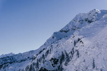 Obraz premium The snowy mountains of the Anzasca valley, near Monte Rosa, during a sunny winter day, near the town of Macugnaga, Italy- December 2019.