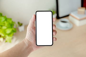 Mockup image blank white screen cell phone.man hand holding texting using mobile on desk at office.background empty space for advertise text.people contact marketing business,technology 