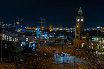 Obraz premium Panoramic shot at night of St Pauli Landungsbruecken landing place in Port of Hamburg between the lower harbour and Fish Market on Elbe river