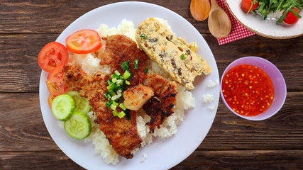 Com Tam - Closeup of vietnamese food: Delicious broken rice with egg pie and BBQ pork chop. fried egg meatloaf and pickles steak grilled pork ribs cucumber onion oil sweet chilies garlic fish sauce