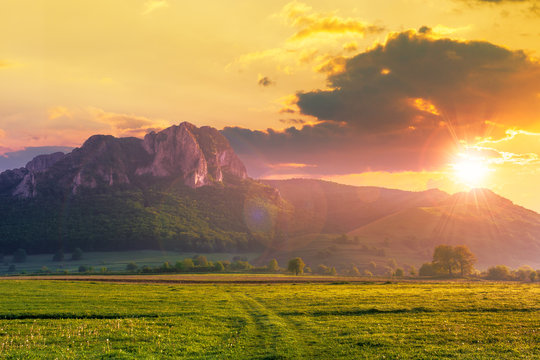 Rock Formation On The Field At Sunset. Beautiful Rural Landscape In Mountains. Wonderful Scenery In Spring. Clouds On The Blue Sky In Evening Light. Forest On The Hills