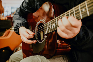 Obraz premium hands of a man on the strings of a guitar