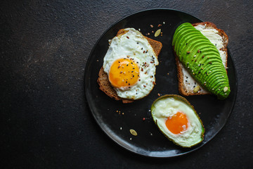 fried eggs in avocado (healthy breakfast, vitamins) menu concept. food background. top view. copy space