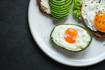 fried eggs in avocado (healthy breakfast, vitamins) menu concept. food background. top view. copy space