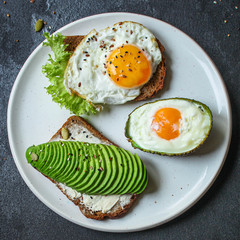 fried eggs in avocado (healthy breakfast, vitamins) menu concept. food background. top view. copy space