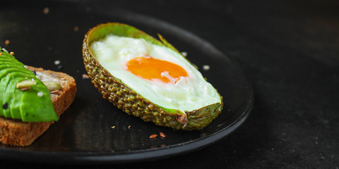 fried eggs in avocado (healthy breakfast, vitamins) menu concept. food background. top view. copy space