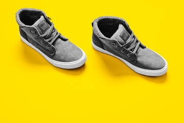 Man fashion gray boots isolated on yellow background.