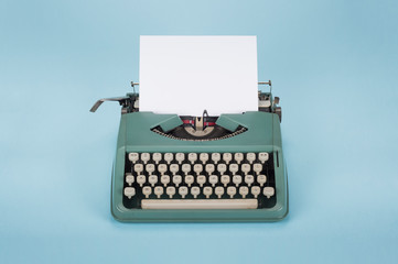 Retro old typewriter with paper on light blue background - 314517268