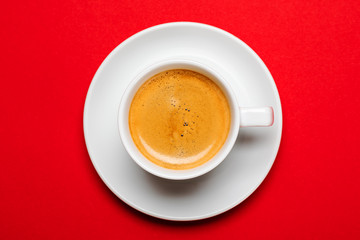 Black coffee in a cup on a red background