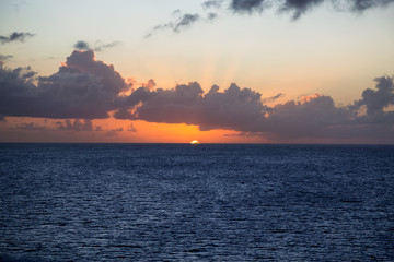 Dramatic View of a cloudscape during a dark and colorful Orange sunset. Taken in the Tropics of Caribbean Sea in Martinique.