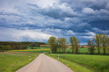 Stormy sky over road thru rural Bavaria in Germany