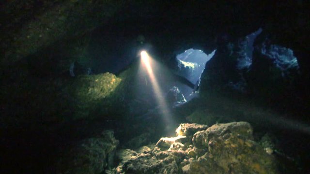 Scubadiver explores under water cave