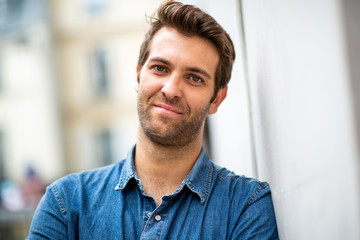 Close up older man leaning against wall and staring